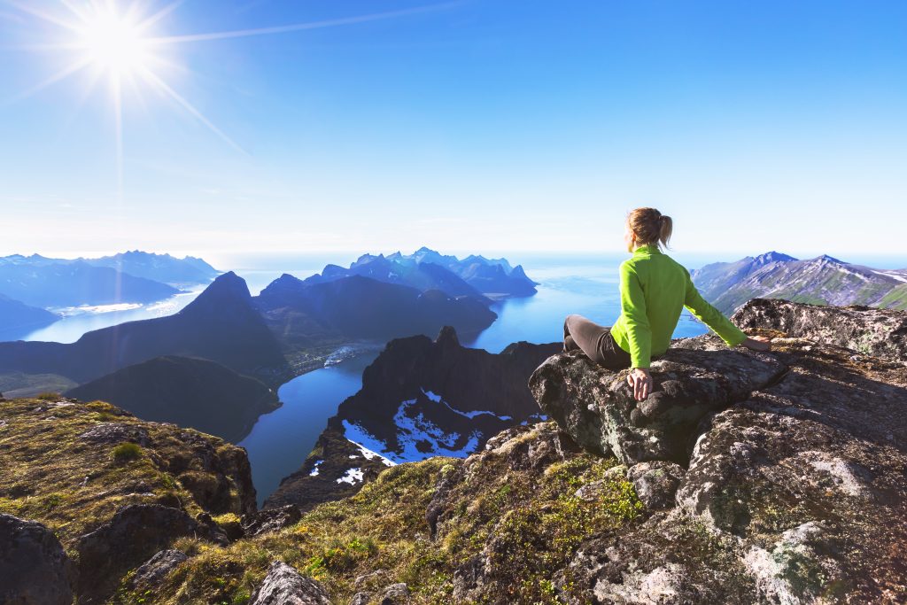 woman relaxing on edge of scenic cliff